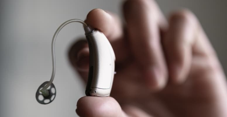 close-up of a hand holding a hearing aid